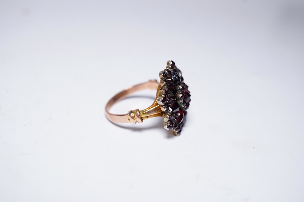 A suite of garnet and paste jewellery, comprising: a brooch, 5cm diameter; a bangle, inner circumference 16cm; two rings, sizes I and M; a pair of earrings, and a single earring, each set with rose-cut garnets; and a pai
